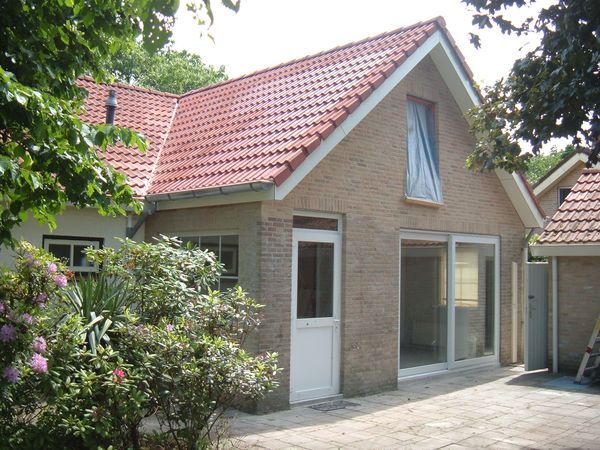 Uitbouw in lichte baksteen met schuifpui.