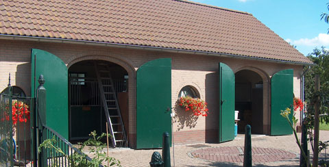 Schuur met groene getoogde deuren.