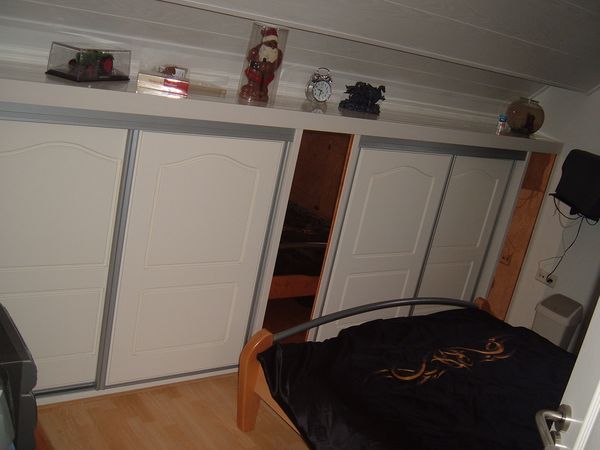 Kastenwand onder een schuin dak, met schuifdeuren.