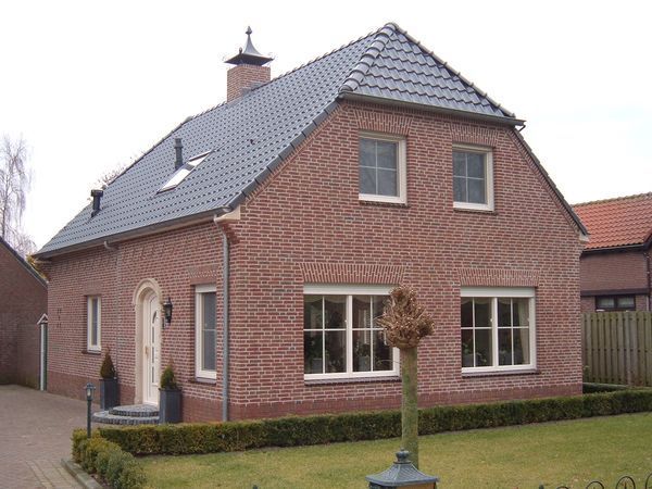 Vrijstaande nieuwbouwwoning in baksteen met kap en schoorsteen.