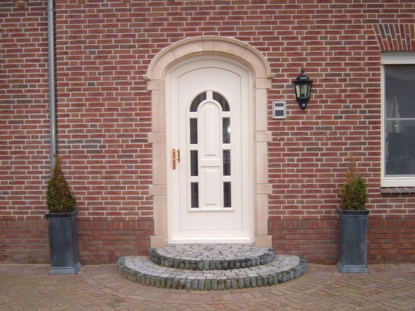 Natuurstenen deuromlijsting in het metselwerk.