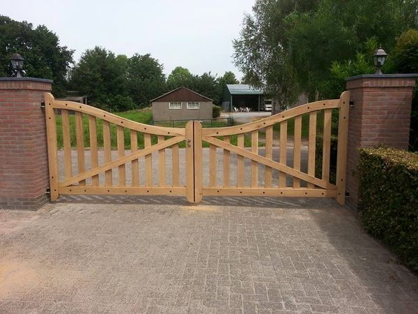 Eiken dubbele poort tussen gemetselde pilaren met lantaarns.